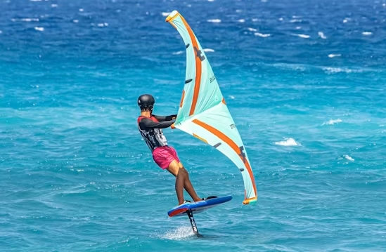 Wing foiling on Koh Samui — rider on hydrofoil with inflatable wing, blue ocean